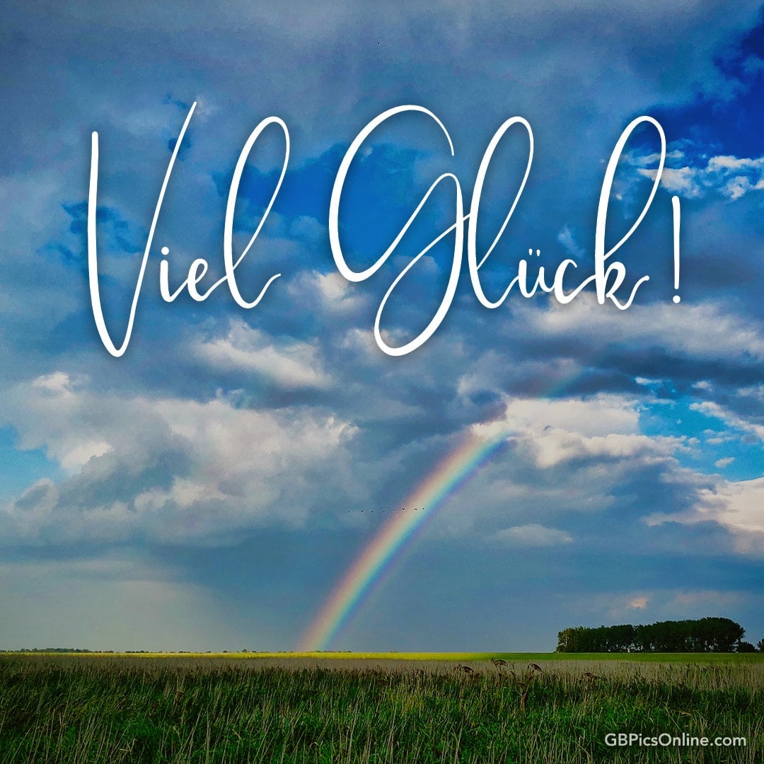Himmel mit Regenbogen und Wolken, darunter der Schriftzug „Viel Glück!“