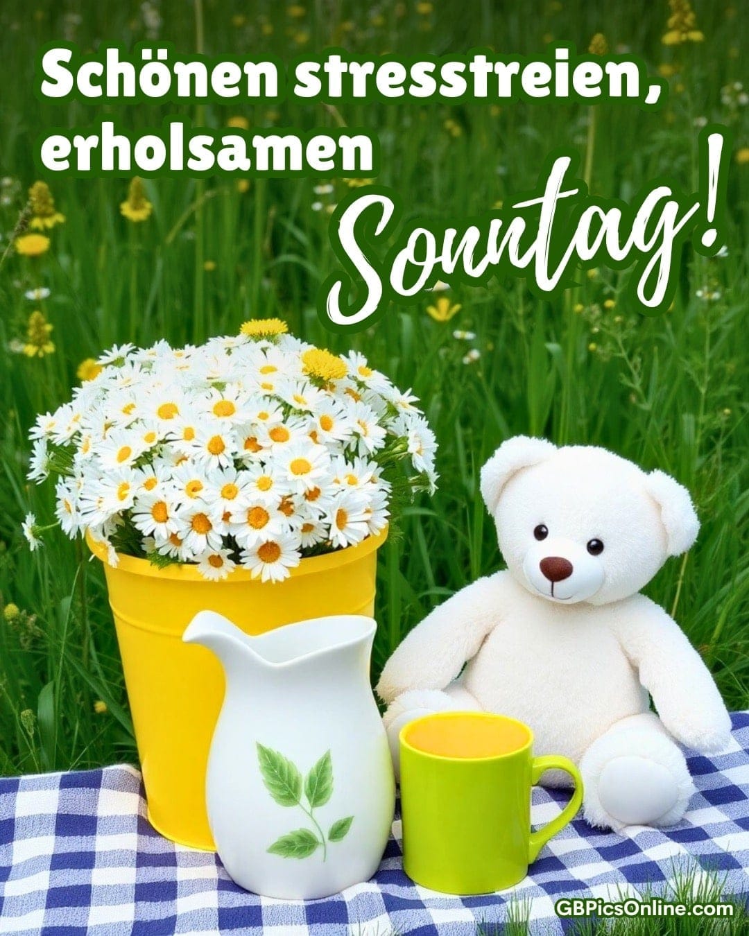Gelber Eimer mit Gänseblümchen, Teddybär und Kaffeetasse auf einer Wiese. Text: Schönen Sonntag!