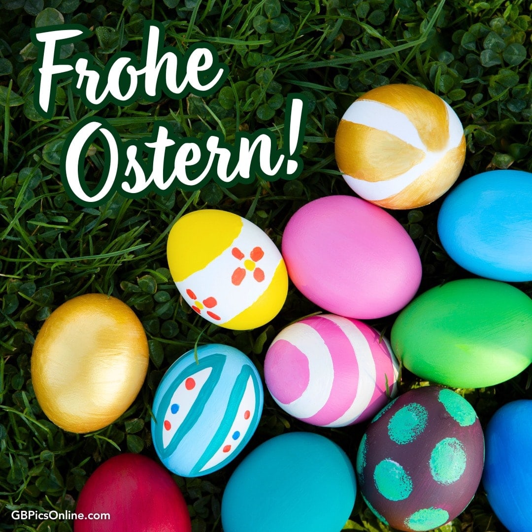 Bunte Ostereier im Gras mit Gruß „Frohe Ostern!“