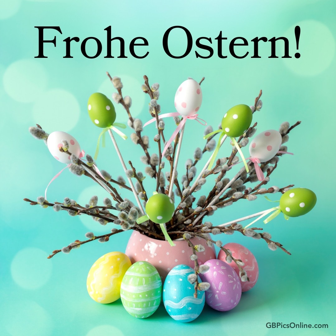 Bunte Ostereier und Weidenkätzchen in einer Vase mit „Frohe Ostern!“ Text
