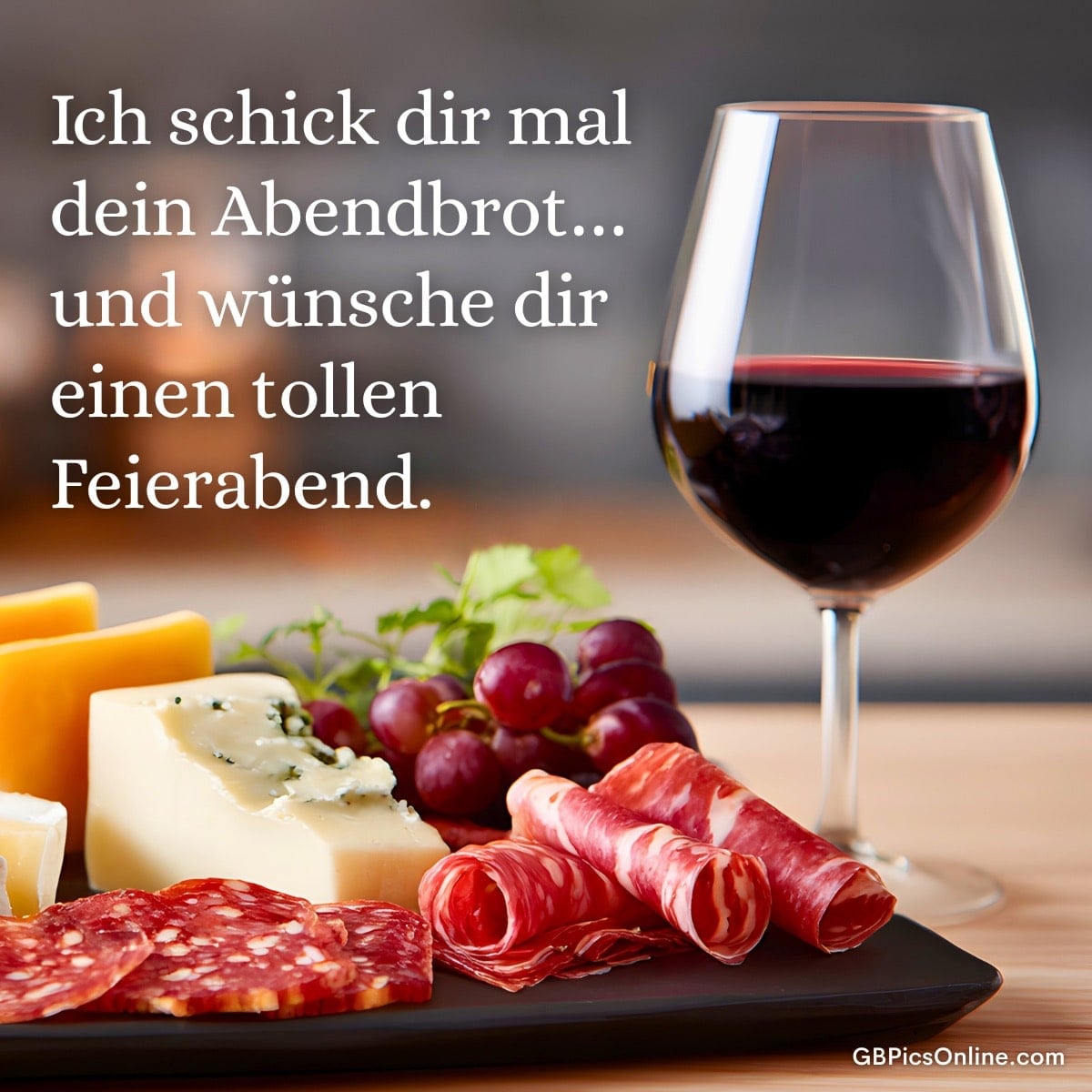 Ein Glas Wein, Käse, Wurst und Trauben auf einem Tisch