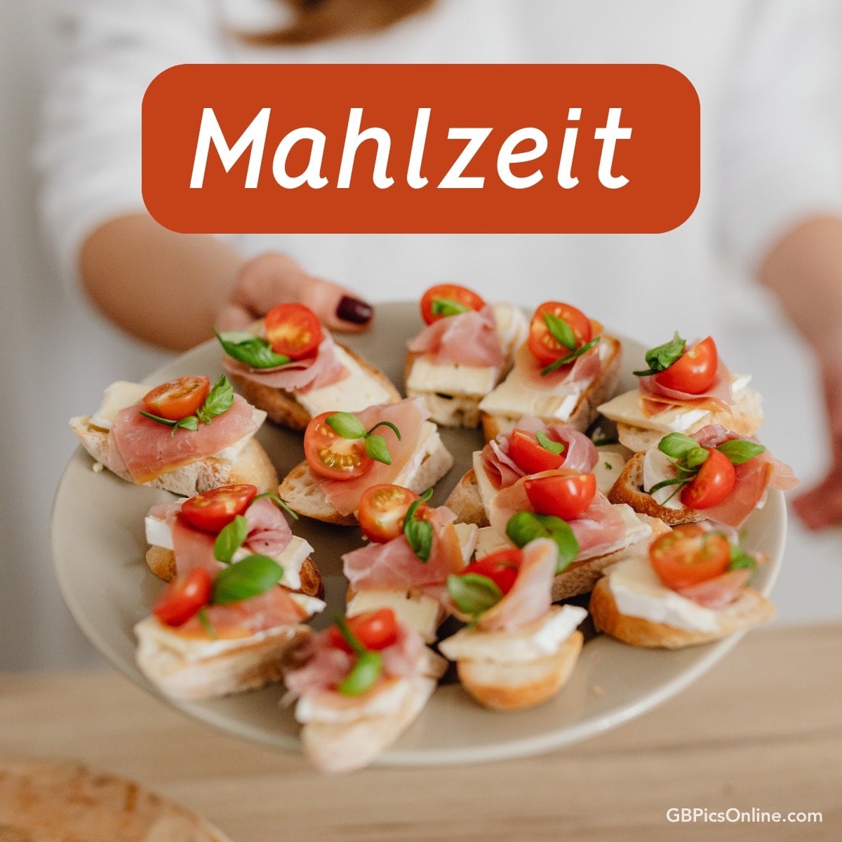 Ein Teller mit köstlichen Häppchen belegt mit Schinken, Käse, Tomaten und Basilikum