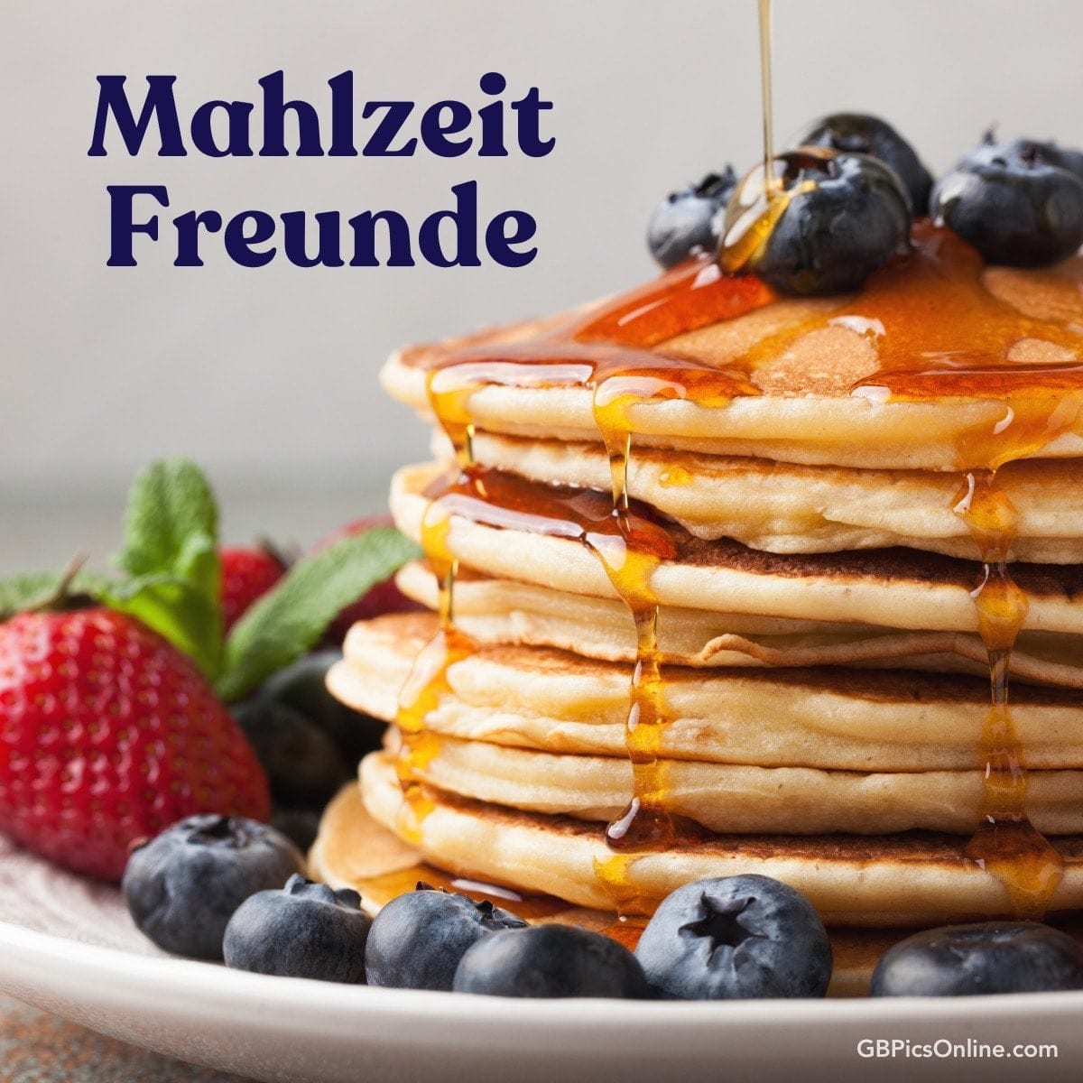 Stapel Pfannkuchen mit Sirup, Blaubeeren und Erdbeeren, „Mahlzeit Freunde“ Text