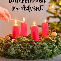 Eine Hand entzündet die erste Kerze auf einem Adventskranz, ein Zeichen der beginnenden Weihnachtszeit.