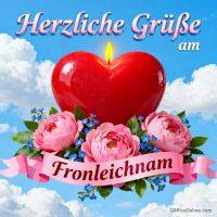 Rotes Herz mit Flamme über rosa Blüten und blauem Himmel, Schriftzug „Herzliche Grüße am Fronleichnam“
