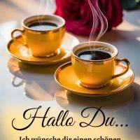 Zwei dampfende Tassen Kaffee auf Untertassen, dahinter eine rote Rose und ein Grußtext