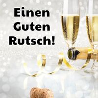 Zwei gefüllte Sektgläser und goldene Luftschlangen schaffen eine glitzernde Silvesterstimmung.