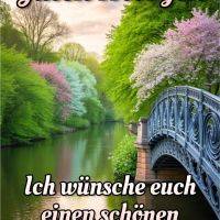 Brücke über ruhigen Fluss, umgeben von grünen und blühenden Bäumen am Morgenhimmel