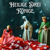 Figuren der Heiligen Drei Könige stehen auf einem festlichen Untergrund. Ein winterlicher Gruß zum Dreikönigstag.