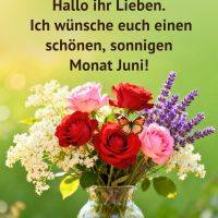 Bunter Blumenstrauß in Glasvase mit Schmetterling davor, dazu Gruß zum 1. Juni