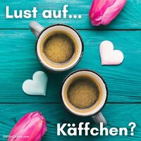 Zwei Tassen Kaffee und ein Hauch von Liebe auf hellem Holztisch, perfekt für eine gemütliche Auszeit.