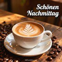 Cappuccino mit Latte-Art auf Holz­tisch, umgeben von Kaffeebohnen; Schriftzug „Schönen Nachmittag“