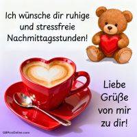 Teddybär mit rotem Herz neben herzförmiger roter Tasse Cappuccino und Grußtext
