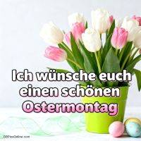 Weiße und rosa Tulpen im grünen Topf, daneben bunte Ostereier und Ostergruß