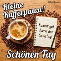 Tasse Kaffee mit Bohnen, daneben Notizblock mit Grußtext und Bleistift auf Holztisch