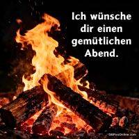 Lagerfeuer mit brennenden Holzscheiten und Funken vor dunklem Hintergrund, Grußtext rechts