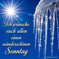 Sonne am blauen Himmel mit glitzernden Eiszapfen und Gruß „Ich wünsche euch allen einen wunderschönen Sonntag“